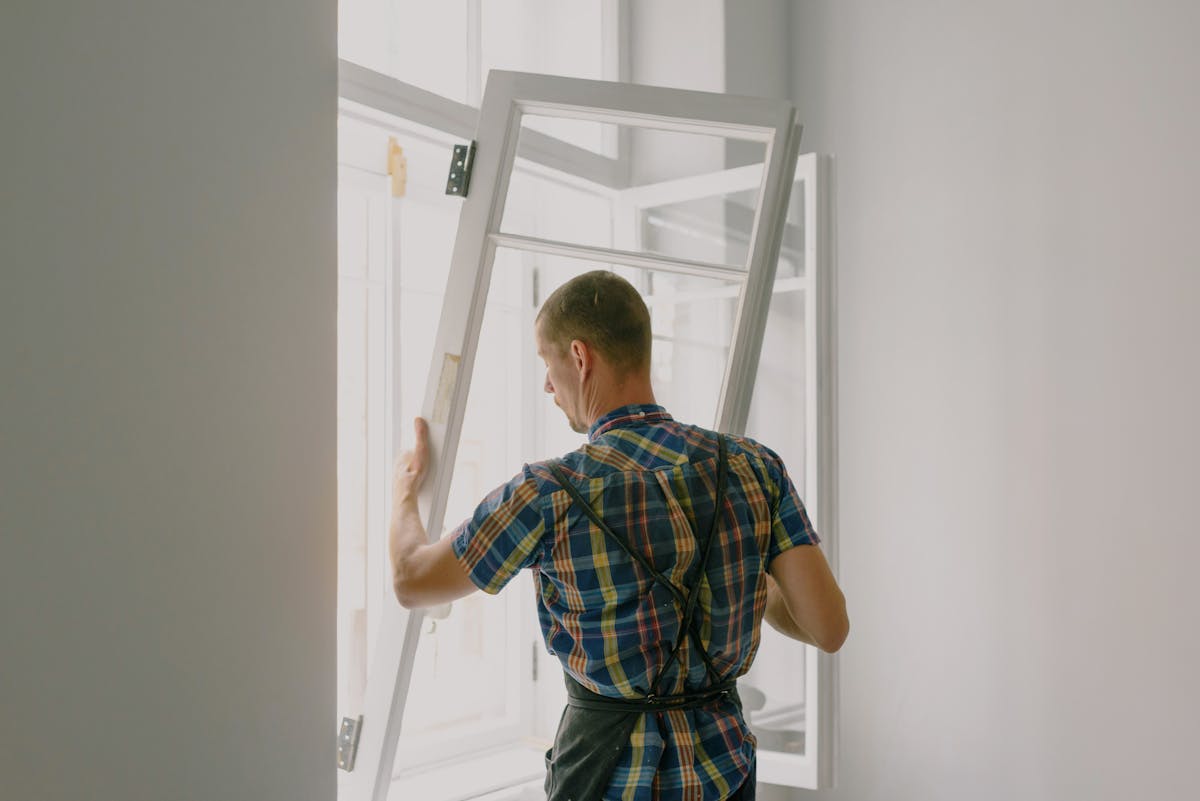 Professional window tint installer working on residential window