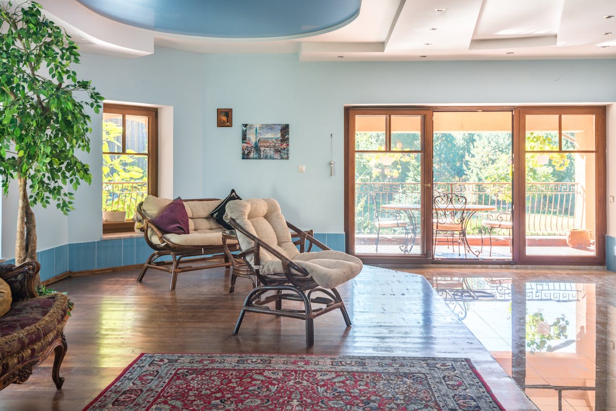 Spacious living room with natural light through large windows, demonstrating the comfort that premium window film provides